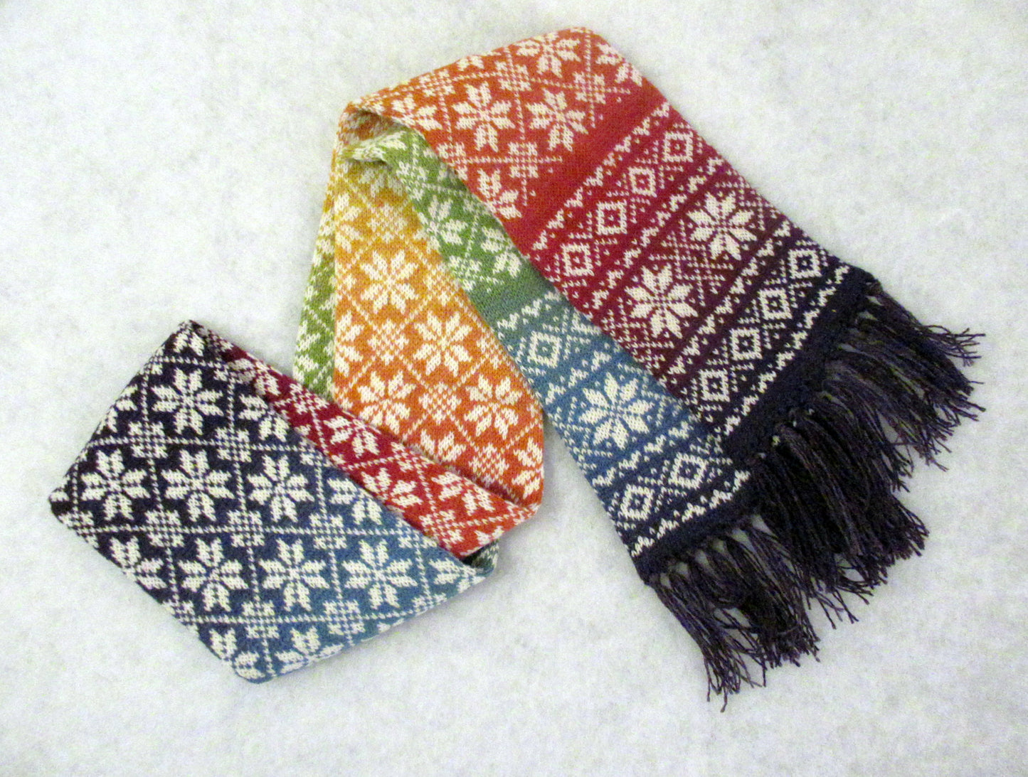 Langer Winterschal Regenbogen mit weißen Sternen.