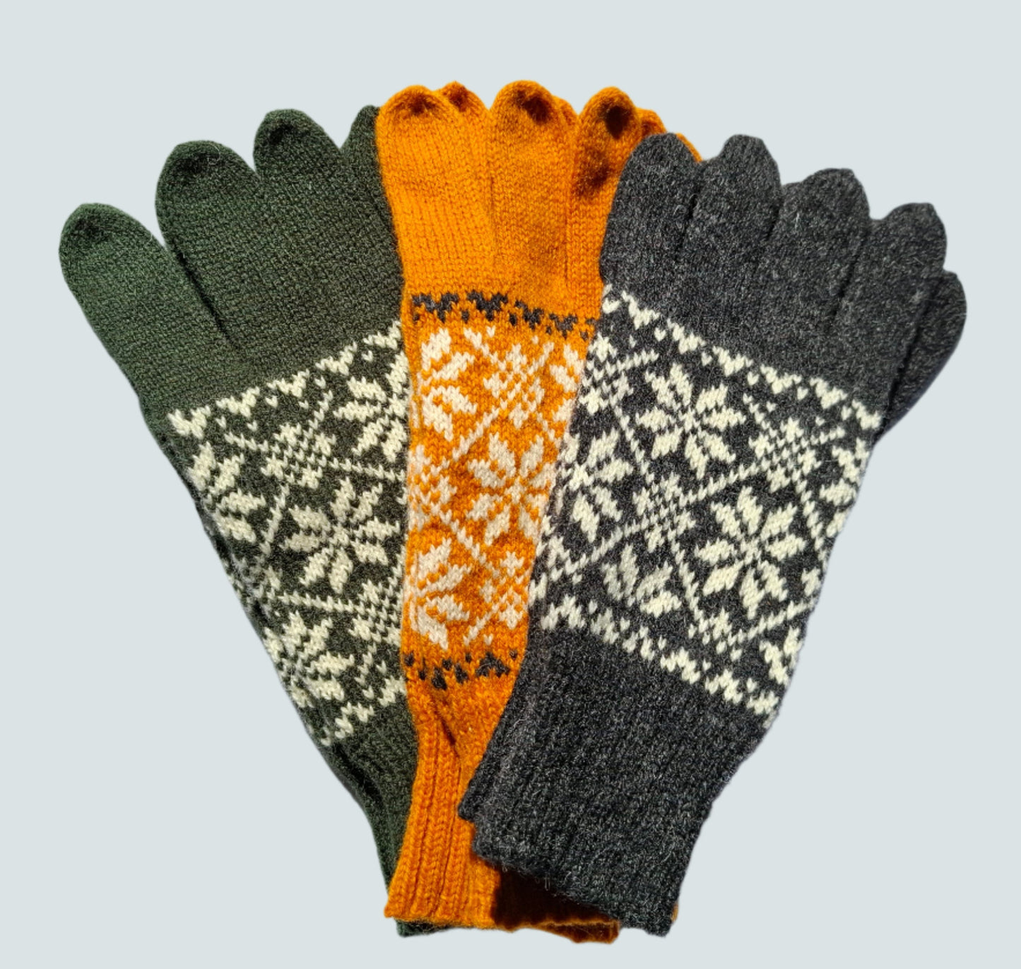 Gestrickte Wollhandschuhe in Hellgrau mit schwarzen Sternen.